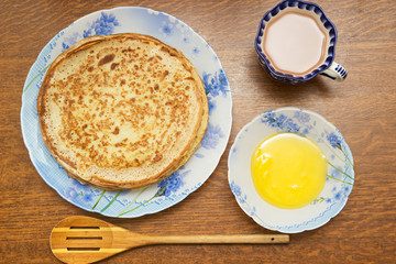 Stack of hot classic Russian thin pancakes. Rustic style. Traditional for the Russian pancake week - Maslenitsa. Honey are near the pancakes. Wooden spoon near the pancakes.