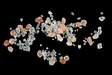 Himalayan pink salt in crystals on black background, top view.