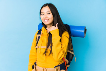 Young chinese backpacker woman isolated showing a mobile phone call gesture with fingers.