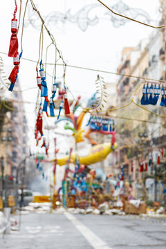 Festival of the Fallas in Valencia. Firecrackers and sculpture of the fallas festival in Valencia in the background. 