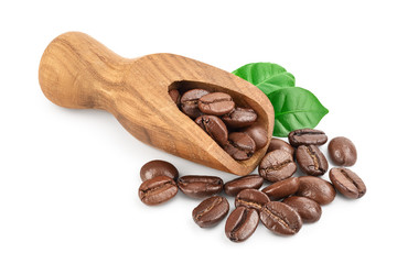 Heap of roasted coffee beans in wooden scoop with leaves isolated on white background with clipping...