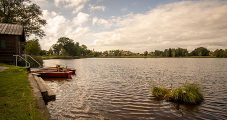 Naklejka na ściany i meble fishermans house with three row boats on the calm evening lake in Bad Bayersoin
