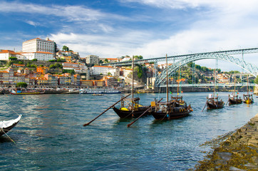 Portugal, Porto, colored houses of old town in Porto, wooden boats on Douro river close up, Porto old town view, a group of boats sailing under a bridge, The Eiffel Bridge, Ponte Dom Luis