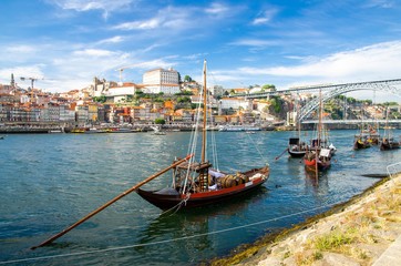 Portugal, city landscape Porto, colored wooden boats with wine port barrels on Douro river, panoramic view of the old town Porto,  The Eiffel Bridge view, Ponte Dom Luis, Porto in summer