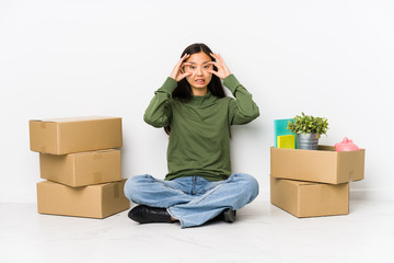 Young chinese woman moving to a new home keeping eyes opened to find a success opportunity.