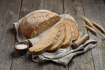 Homemade wheat rye bread on a wooden background. Sliced loaf of bread. Selective focus