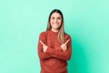 Obraz premium Young caucasian woman isolated points sideways, is trying to choose between two options.