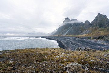 View over Eystrahorn mountain chain and Hvalnes beach next to the Ring road in Iceland. Foggy and overcast weather. Traveling and icelandic concept.
