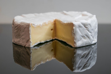 Camembert cheese on a table with vegetables