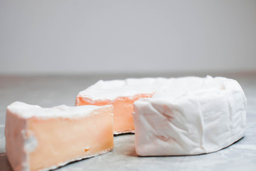 Camembert cheese on a table with vegetables