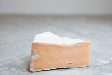 Camembert cheese on a table with vegetables