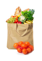 Eco friendly reusable shopping bag filled with bread, fruits and vegetables on a white background tangerines in grid beside