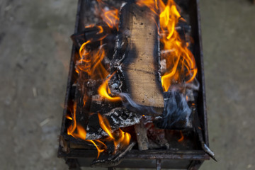 Burning firewood in a rusty barbecue