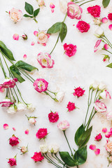 Background with roses and lisianthus  or Japanese roses flowers scattered on rustic white and gold surface. Top view, blank space