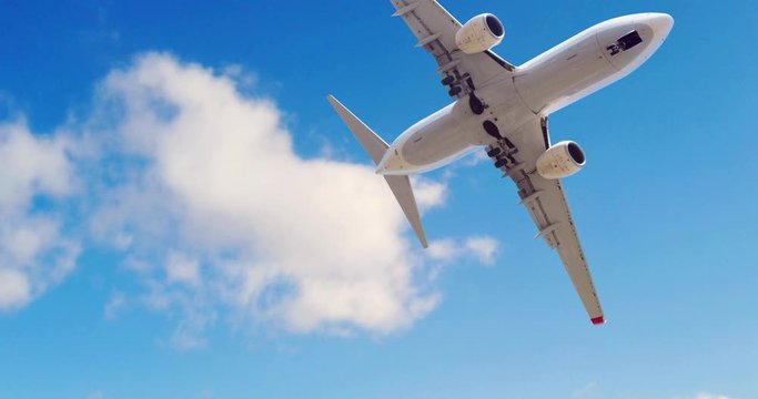 Airplane at take off seen from the bottom. Airplane in the blue sky with white clouds. Commercial plane in a flight close up, bottom view.