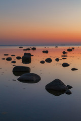Fototapeta na wymiar Colorful sunset with clear sky over rocky shore of Baltic sea.