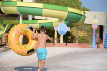 Active Caucasian boy with floater in water park in Spain. Back view. - 317567536