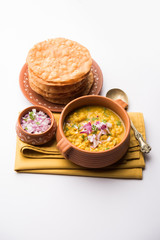 Dal pakwan is an authentic Sindhi breakfast. It is a combination of deepfried, crisp and unpuffed Maida puris served with Daal made using chana or split chickpea. selective focus