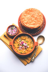 Dal pakwan is an authentic Sindhi breakfast. It is a combination of deepfried, crisp and unpuffed Maida puris served with Daal made using chana or split chickpea. selective focus