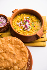 Dal pakwan is an authentic Sindhi breakfast. It is a combination of deepfried, crisp and unpuffed Maida puris served with Daal made using chana or split chickpea. selective focus