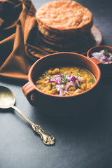 Dal pakwan is an authentic Sindhi breakfast. It is a combination of deepfried, crisp and unpuffed Maida puris served with Daal made using chana or split chickpea. selective focus