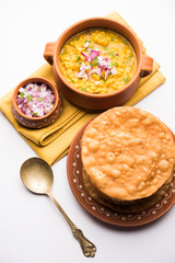 Dal pakwan is an authentic Sindhi breakfast. It is a combination of deepfried, crisp and unpuffed Maida puris served with Daal made using chana or split chickpea. selective focus