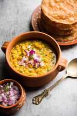 Dal pakwan is an authentic Sindhi breakfast. It is a combination of deepfried, crisp and unpuffed Maida puris served with Daal made using chana or split chickpea. selective focus