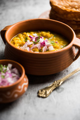Dal pakwan is an authentic Sindhi breakfast. It is a combination of deepfried, crisp and unpuffed Maida puris served with Daal made using chana or split chickpea. selective focus