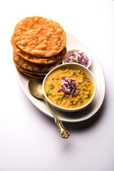 Dal pakwan is an authentic Sindhi breakfast. It is a combination of deepfried, crisp and unpuffed Maida puris served with Daal made using chana or split chickpea. selective focus