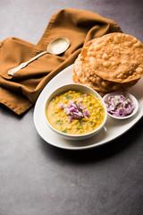 Dal pakwan is an authentic Sindhi breakfast. It is a combination of deepfried, crisp and unpuffed Maida puris served with Daal made using chana or split chickpea. selective focus