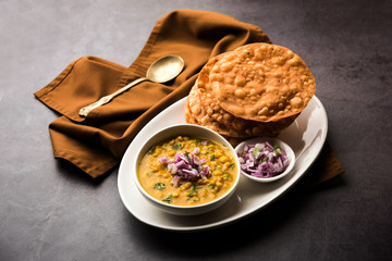 Dal pakwan is an authentic Sindhi breakfast. It is a combination of deepfried, crisp and unpuffed Maida puris served with Daal made using chana or split chickpea. selective focus