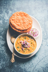 Dal pakwan is an authentic Sindhi breakfast. It is a combination of deepfried, crisp and unpuffed Maida puris served with Daal made using chana or split chickpea. selective focus