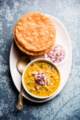 Dal pakwan is an authentic Sindhi breakfast. It is a combination of deepfried, crisp and unpuffed Maida puris served with Daal made using chana or split chickpea. selective focus