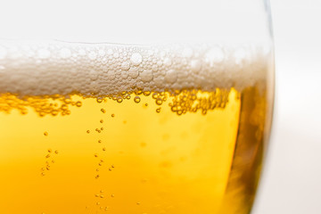 Light beer in a glass, macro photo. Above is foam. Abstract background image of a drink.