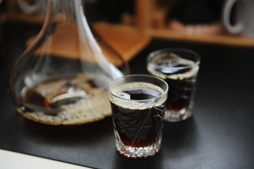 Aerated black filter coffee served in decanter and two glasses. Third wave specialty aesthetics