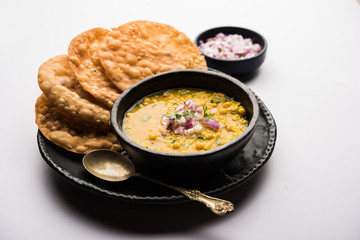 Dal pakwan is an authentic Sindhi breakfast. It is a combination of deepfried, crisp and unpuffed Maida puris served with Daal made using chana or split chickpea. selective focus