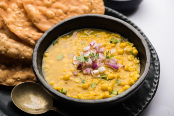 Dal pakwan is an authentic Sindhi breakfast. It is a combination of deepfried, crisp and unpuffed Maida puris served with Daal made using chana or split chickpea. selective focus