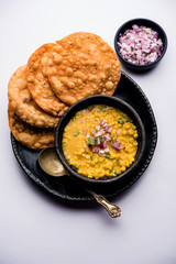 Dal pakwan is an authentic Sindhi breakfast. It is a combination of deepfried, crisp and unpuffed Maida puris served with Daal made using chana or split chickpea. selective focus