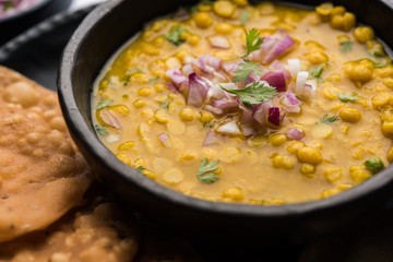 Dal pakwan is an authentic Sindhi breakfast. It is a combination of deepfried, crisp and unpuffed Maida puris served with Daal made using chana or split chickpea. selective focus