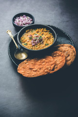 Dal pakwan is an authentic Sindhi breakfast. It is a combination of deepfried, crisp and unpuffed Maida puris served with Daal made using chana or split chickpea. selective focus