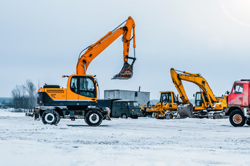 Excavator is loading excavation to the truck. Excavators hydraulic are heavy construction equipment consisting of a boom, dipper or stick , bucket and cab on a rotating platform