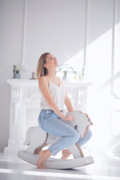 Young Adult Girl On A Rocking Horse / Unusual Photo Of A Girl In The Studio Funny Laugh