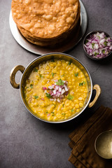 Dal pakwan is an authentic Sindhi breakfast. It is a combination of deepfried, crisp and unpuffed Maida puris served with Daal made using chana or split chickpea. selective focus