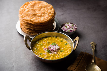 Dal pakwan is an authentic Sindhi breakfast. It is a combination of deepfried, crisp and unpuffed Maida puris served with Daal made using chana or split chickpea. selective focus