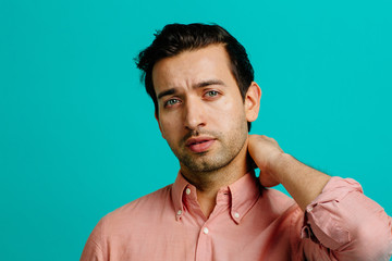 Portrait of a young adult man smiling,  isolated on blue studio background