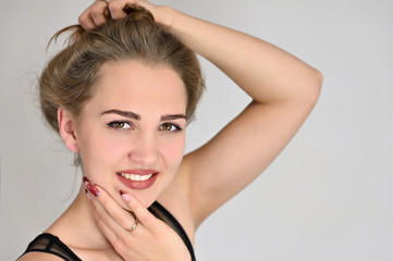 Obraz premium Generic female portrait concept for cosmetics advertising on a white background. A large photo of a pretty smiling girl with long hair and excellent make-up is standing in different poses.