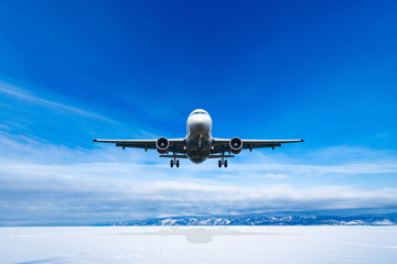 Landing of the passenger plane at winter day time.