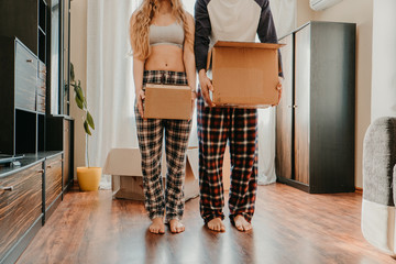 Plakat Moving day. Happy couple in their new apartment is having fun with cardboard boxes. Cheerful young couple in new house at moving day