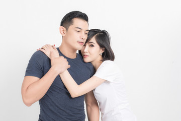Naklejka premium Portrait of happy young couple embracing in studio shot on white background.