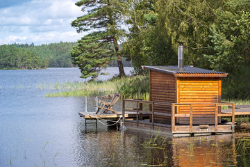 View of a small sauna by a lake, on a jetty.